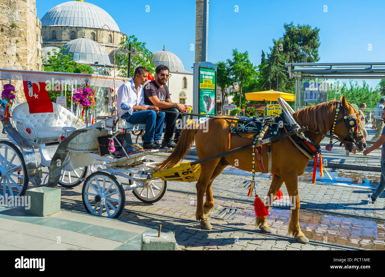 ANTALYA, Türkei - 11. MAI 2017: Die altmodischen Kutsche in der Cumhuriyet (Republik) Straße mit der riesigen Kuppel des Tekeli Mehmet Pasa Moschee Stockfoto