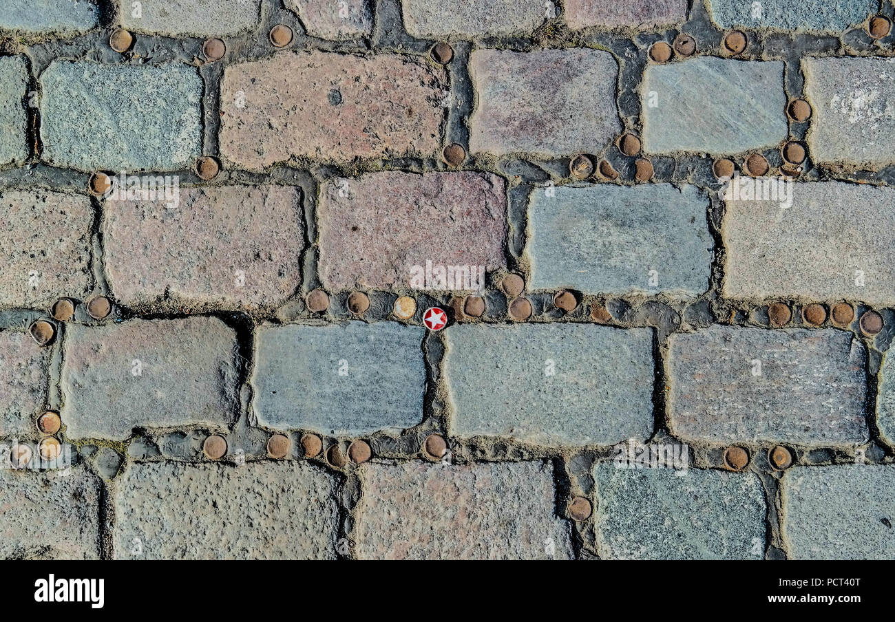 Kopfsteinpflaster an der Admiralbrücke, Kreuzberg, Berlin, Deutschland, geometrische urbane Textur mit Bierflaschenverschlüssen Stockfoto