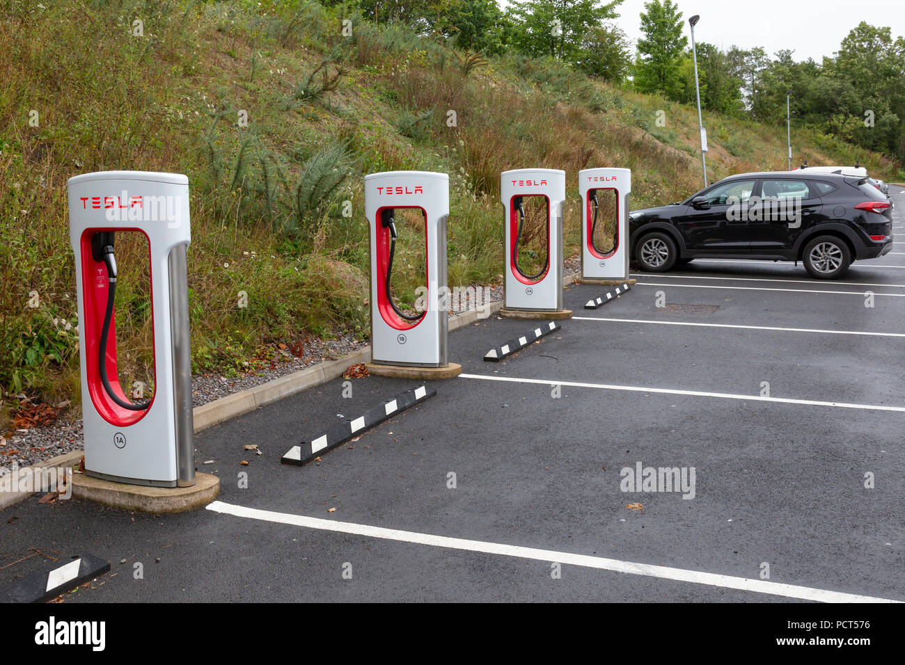 SARN, Großbritannien - 2 August, 2018: eine Reihe von Tesla Superchargers neben leeren Parkplätze an der Sarn Park Autobahn Dienstleistungen aus der M4 in der Nähe von Bri Stockfoto