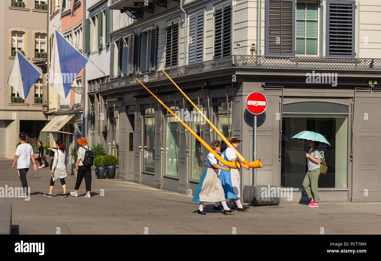 Zürich, Schweiz - 1 August 2018: Menschen, die alpine Hörner, die entlang einer Straße in der Altstadt der Stadt Zürich in der para teilzunehmen Stockfoto Zürich, Schweiz - 1 August 2018: Menschen, die alpine Hörner, die entlang einer Straße in der Altstadt der Stadt Zürich in der para teilzunehmen Stockfoto