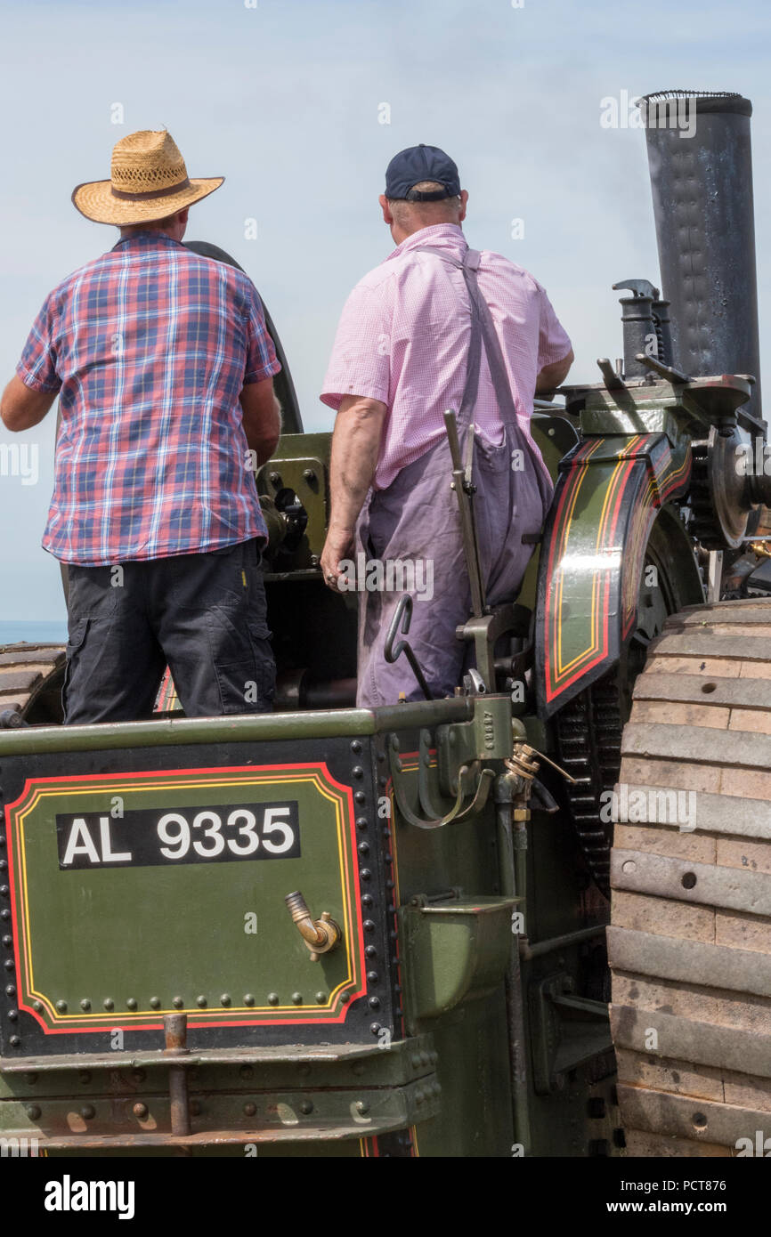 Zwei ältere Männer oder fahren eine große Zugmaschine Dampf angetriebene Fahrzeug oder Dampfwalze bei einem landwirtschaftlichen zeigen. Stockfoto