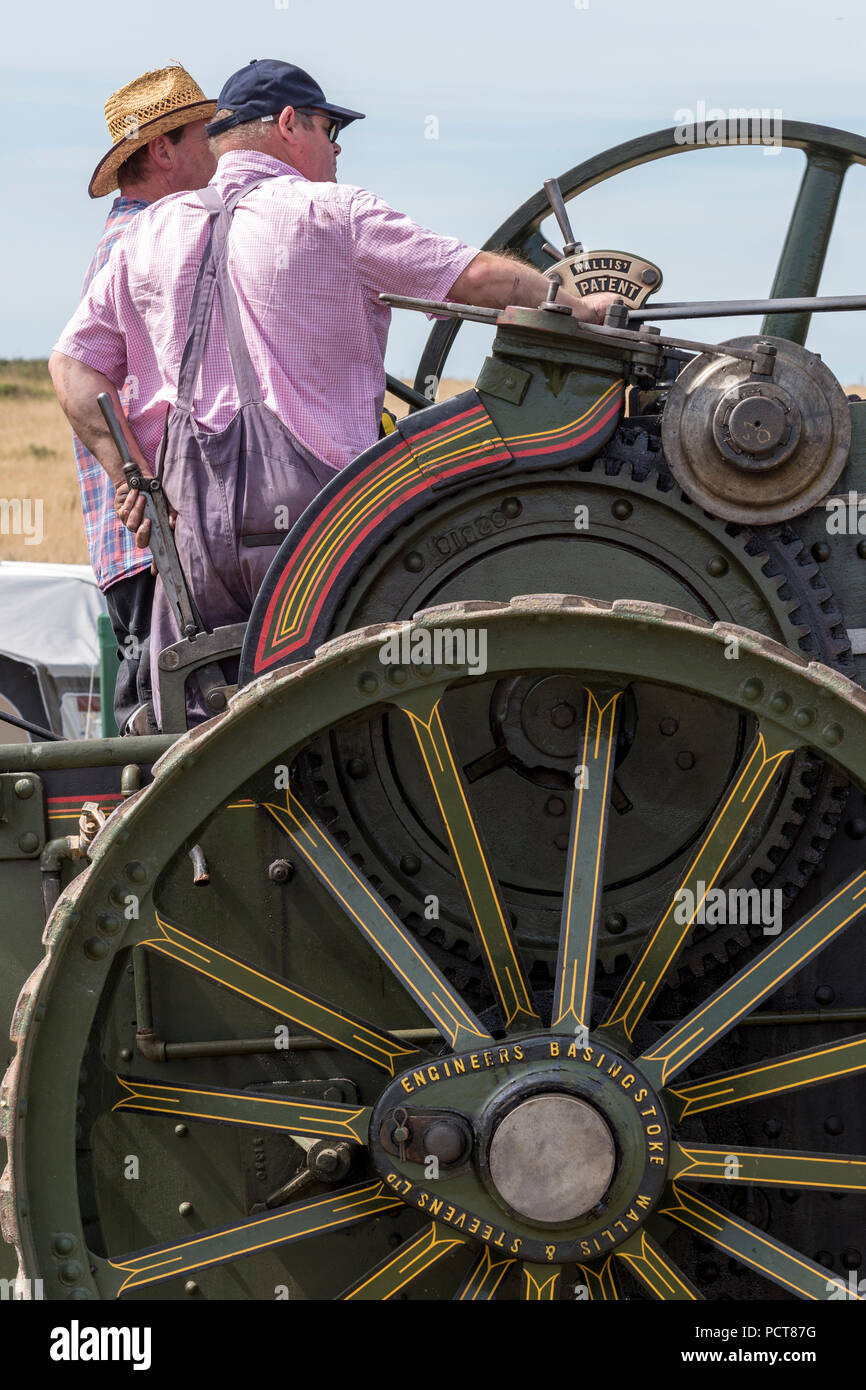 Zwei ältere Männer oder fahren eine große Zugmaschine Dampf angetriebene Fahrzeug oder Dampfwalze bei einem landwirtschaftlichen zeigen. Stockfoto