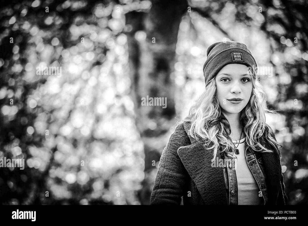 Junge Mädchen im Freien mit Kappe, Portrait im Wald, ernst in die Kamera schaut, Schwarz/Weiß-Bild Stockfoto