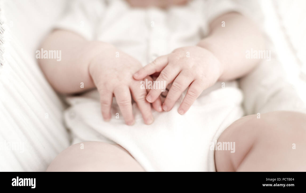 Die Hände eines Babys, der 7/8-baby Oberkörper, verschwommenen Hintergrund Stockfoto