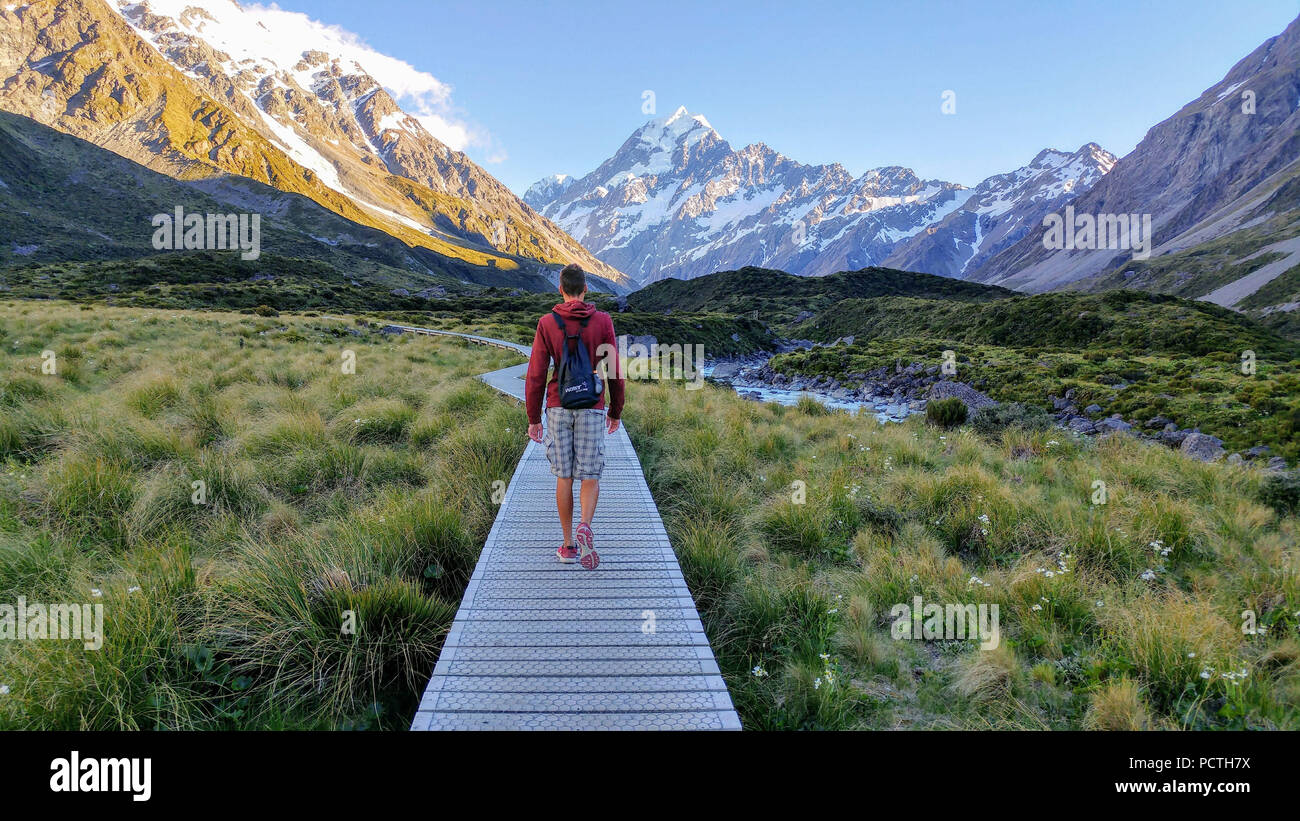 Neuseeland, schneebedeckte Berge, Person läuft über eine Fußgängerbrücke Stockfoto