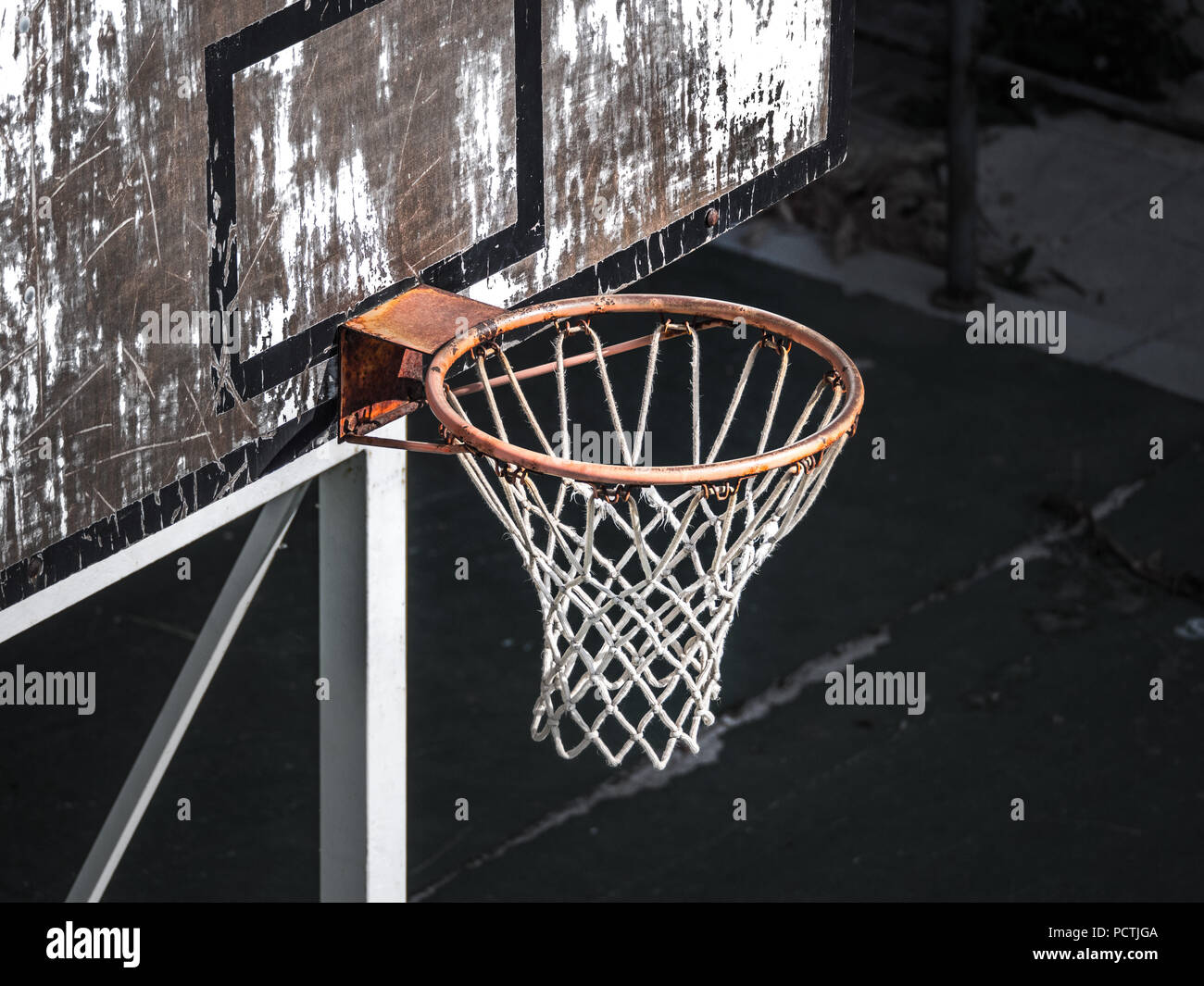 Nahaufnahme einer verwitterten alten orange Basketballkorb und net von oben auf dem Spielplatz in Europa mit weiß lackierten Rückwand mit schwarzem Rand Stockfoto