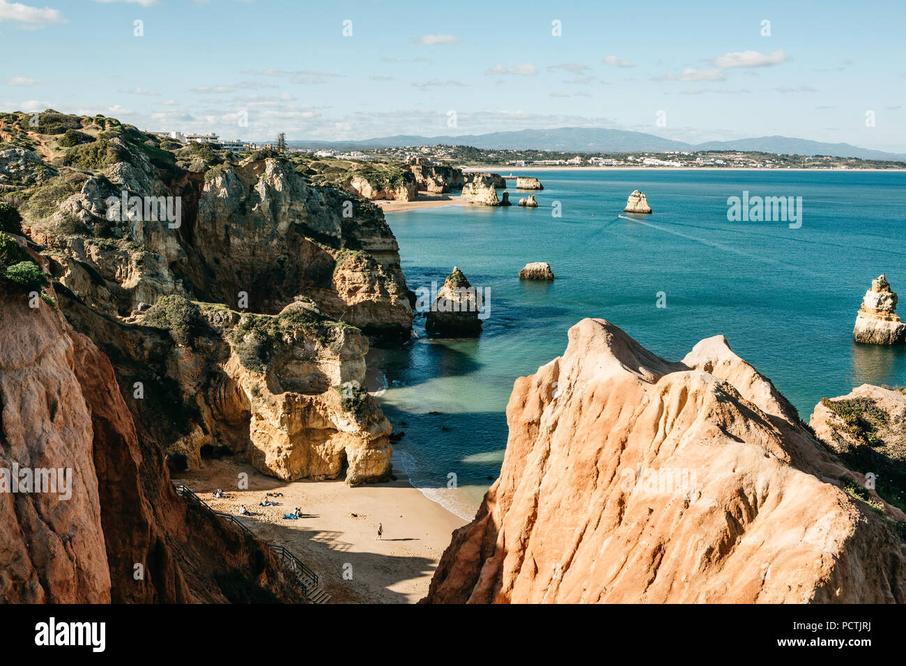 Schöne Aussicht auf den Atlantischen Ozean vor der Küste von Portugal in der Nähe der Stadt Lagos. Die Leute am Strand sonnen, schwimmen und während der Ferien oder Wochenenden oder Feiertagen entspannen Stockfoto