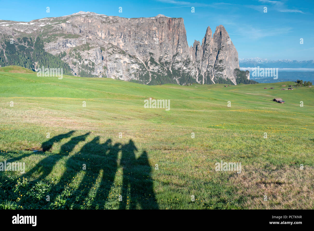 Europa, Italien, Bozen, Südtirol, Seiser Alm - Seiser Alm. Urige Hütten auf der Seiser Alm Wiesen und die Schatten einer Gruppe von Wanderer, im Hintergrund der Schlern, Dolomiten Stockfoto