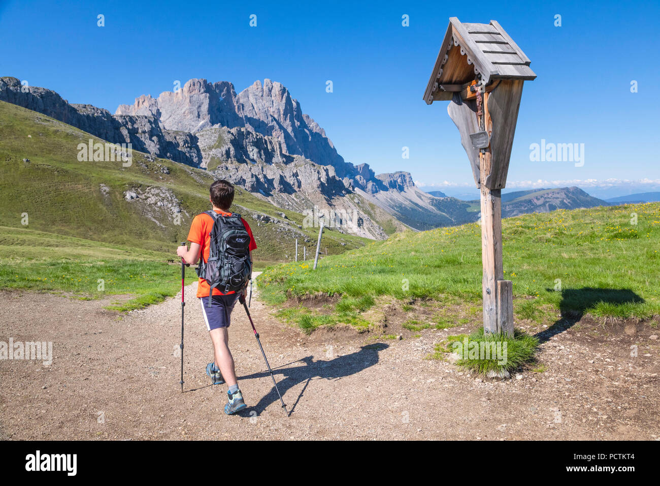 Junger Mann, Wanderer an Poma pass/Kreuzkofeljoch mit dem Bergmassiv Geisler/Geisler im Hintergrund, Naturpark Puez-Geisler, Dolomiten, Bozen, Südtirol, Italien Stockfoto