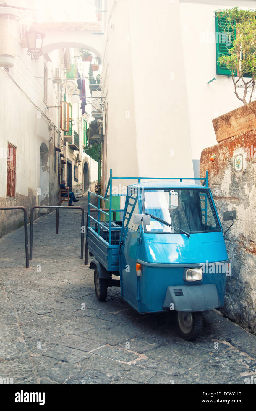 Kreuz - verarbeitete Bild des alten blauen Italienischen dreirädrigen Auto auf sonnigen Abend auf schmalen Straße geparkt in der kleinen Stadt von Vietri Sul Mare an der Amalfi Küste, Stockfoto