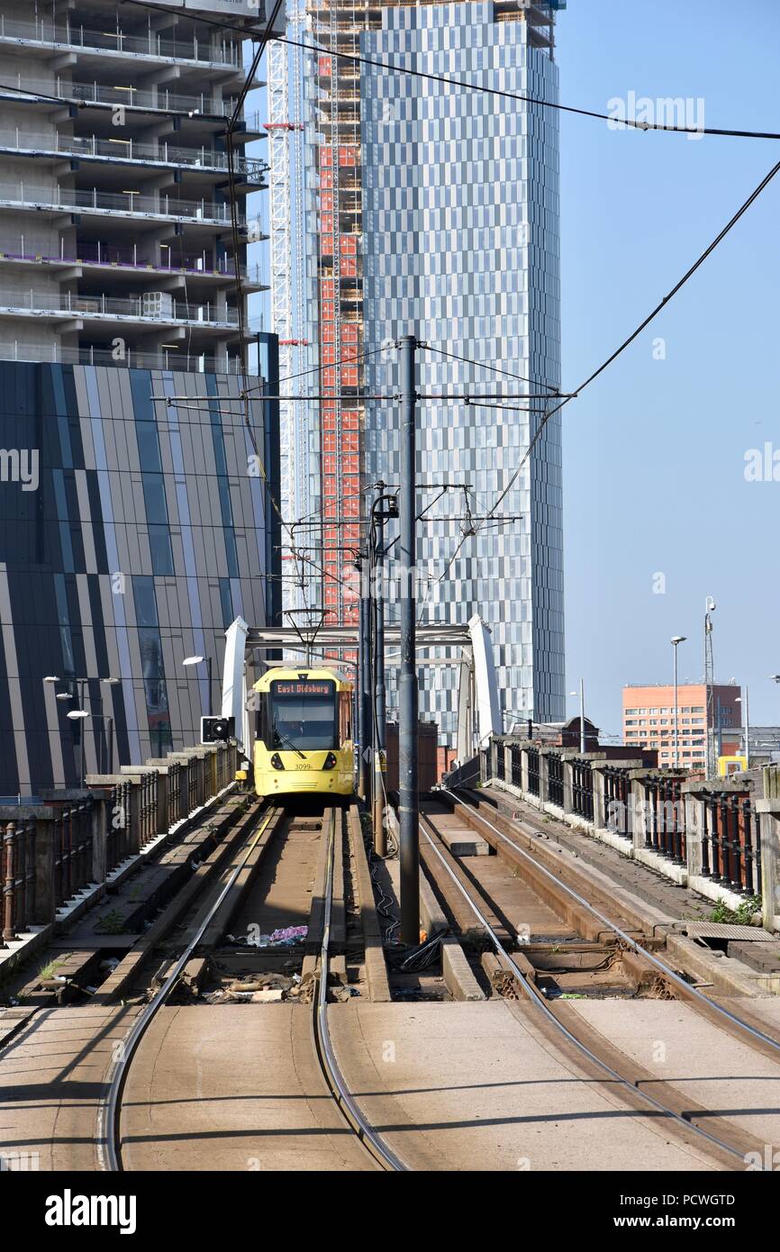 Eine Ansicht eines MetroLink Tram im Stadtzentrum von Manchester, moderne Gebäude im Bau im Hintergrund. Mai 2018 Stockfoto