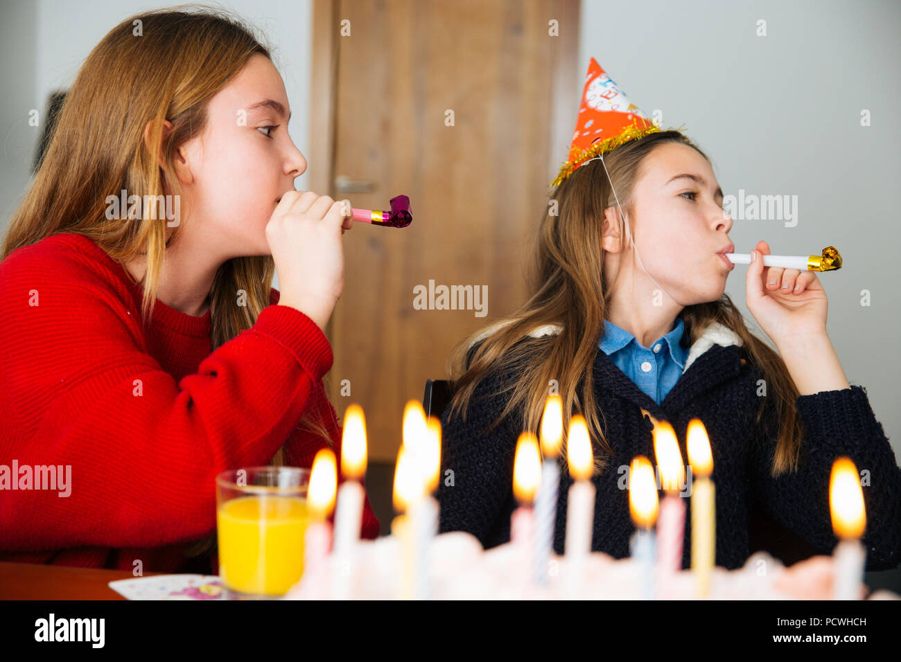 Gruppe Kinder feiern Geburtstag zusammen und bläst in die Pfeifen Stockfoto