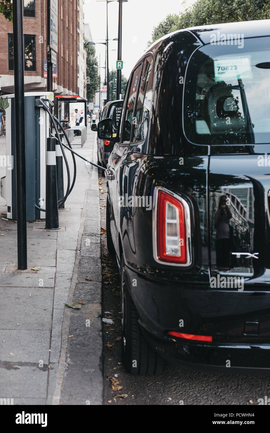 Neue elektrische LEVC TX London black cab Laden aus ändern Punkt auf einer Straße in London, UK. Stockfoto