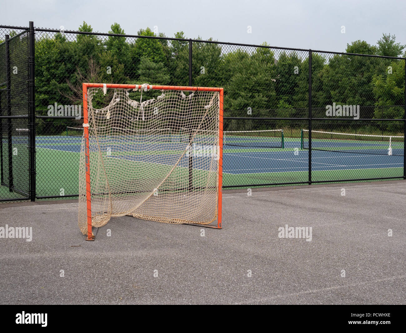 Offseason, Beat up, verrostet, zackige lacrosse Ziel sitzen auf Asphalt Gericht mit Netzen reißen Stockfoto