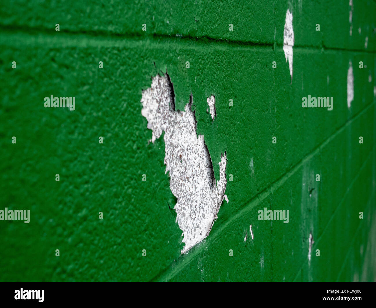 In der Nähe von Grün die Farbe blätterte von der Wand in mehreren Spots Stockfoto