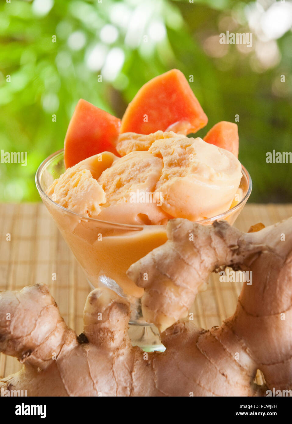 Schüssel mit tropischen papaya Ingwereis mit Stücken von payapa und Ingwer serviert im Freien Stockfoto