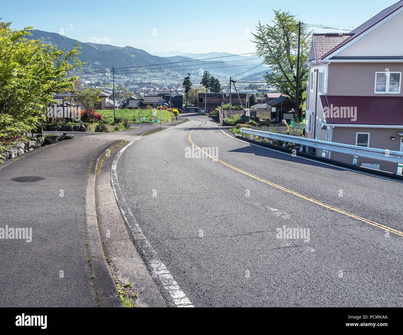 Geschwungene Straße der Yufuin Dorf umgeben von Bergen in Japan Stockfoto
