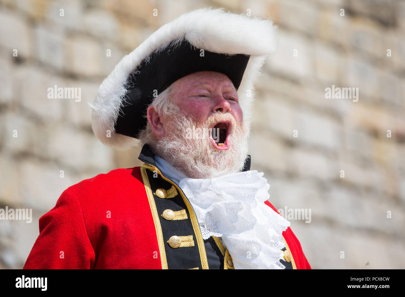 Windsor, Großbritannien. 4. August 2018. Trevor Heeks, Stadtausrufer von Trowbridge, nimmt teil an der Alten und ehrenvolle Gilde Town Criers (AHGTC) nationalen Meisterschaft unter den Mauern von Schloss Windsor. 40 Town criers aus ganz Großbritannien und zwei aus Australien konkurrieren in zwei Runden von Weinen, die ersten, die ein Home Schrei auf Diktion, den Tonfall, die Klarheit und die Lautstärke und die zweite ein Schrei auf das Thema 'Feier' gezählt. Credit: Mark Kerrison/Alamy leben Nachrichten Stockfoto