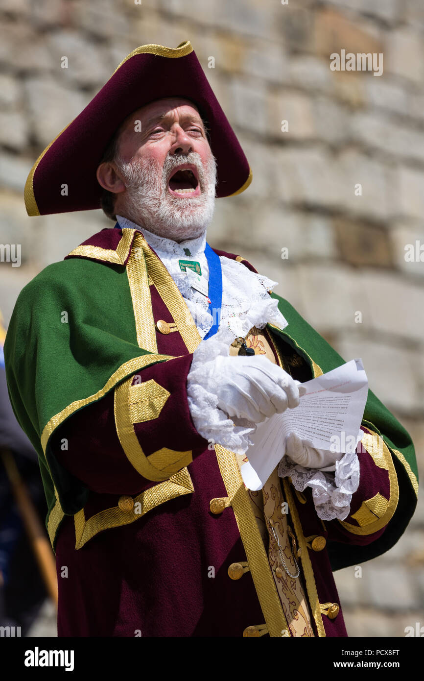 Windsor, Großbritannien. 4. August 2018. Paul Gough Stadtausrufer von Nuneaton und Bedworth, nimmt teil an der Alten und ehrenvolle Gilde Town Criers (AHGTC) nationalen Meisterschaft unter den Mauern von Schloss Windsor. 40 Town criers aus ganz Großbritannien und zwei aus Australien konkurrieren in zwei Runden von Weinen, die ersten, die ein Home Schrei auf Diktion, den Tonfall, die Klarheit und die Lautstärke und die zweite ein Schrei auf das Thema 'Feier' gezählt. Credit: Mark Kerrison/Alamy leben Nachrichten Stockfoto