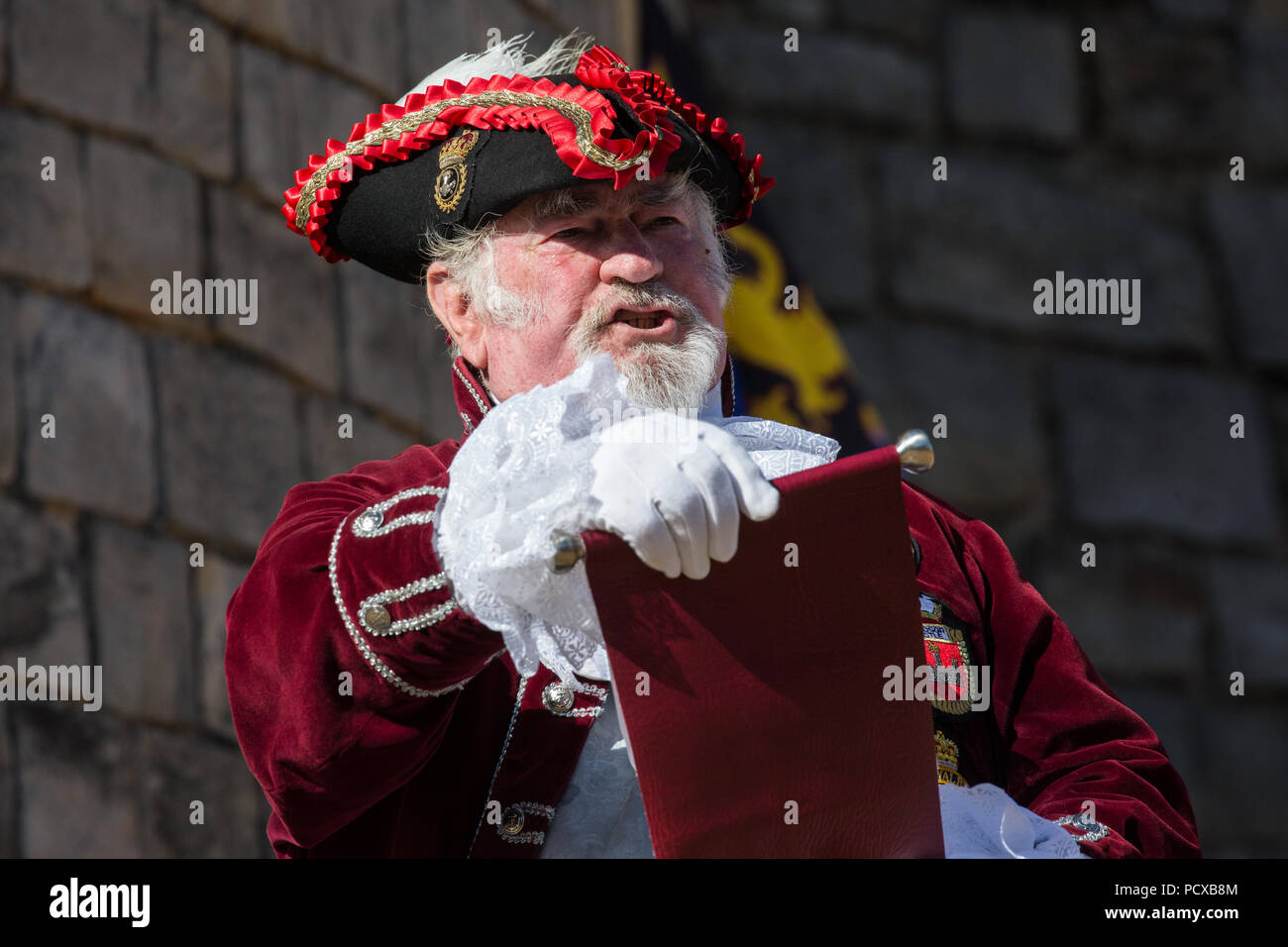 Windsor, Großbritannien. 4. August 2018. Andrew Fox, Stadtausrufer von Ilminster, beteiligt sich an der Antike und ehrenvolle Gilde Town Criers (AHGTC) nationalen Meisterschaft unter den Mauern von Schloss Windsor. 40 Town criers aus ganz Großbritannien und zwei aus Australien konkurrieren in zwei Runden von Weinen, die ersten, die ein Home Schrei auf Diktion, den Tonfall, die Klarheit und die Lautstärke und die zweite ein Schrei auf das Thema 'Feier' gezählt. Credit: Mark Kerrison/Alamy leben Nachrichten Stockfoto