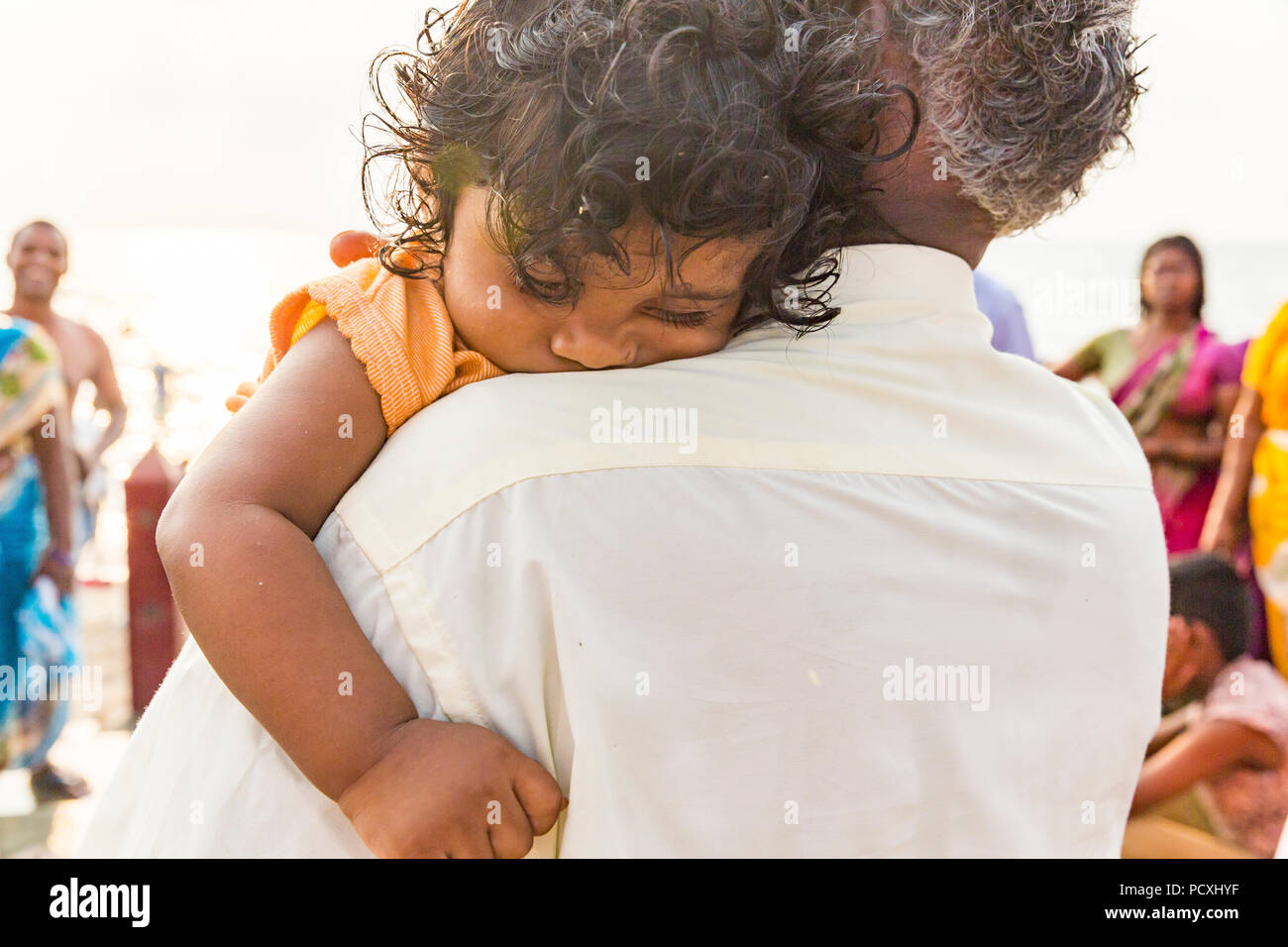 RAMESHWARAM, Tamil Nadu, Indien - MÄRZ CIRCA, 2018. Lächelnd indisches Kind in den Armen seines Vaters. Stockfoto