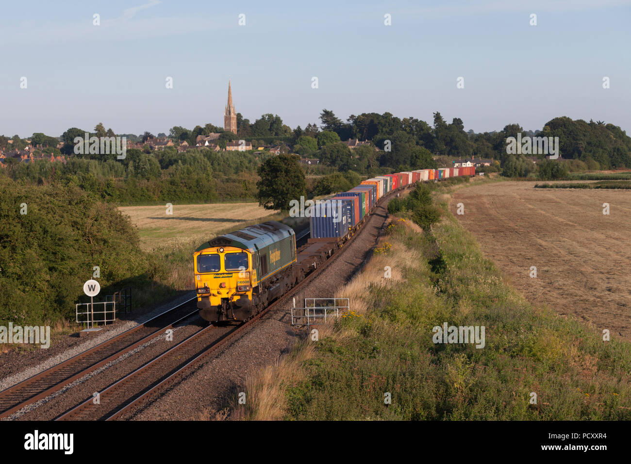 Ein Freightliner Class 66 Lokomotive, passieren sie dass Kings Sutton (südlich von Banbury) mit einem Zug von Containern von Southampton nach Manchester Trafford Park Stockfoto