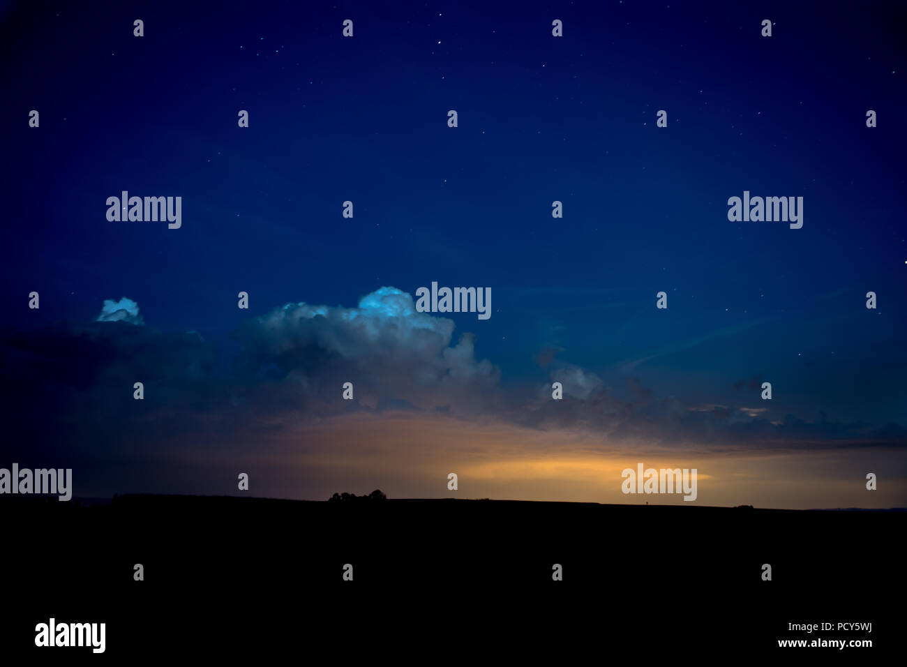 Nightsky blau mit Sternen und Wolken über Silhouette Landschaft Stockfoto