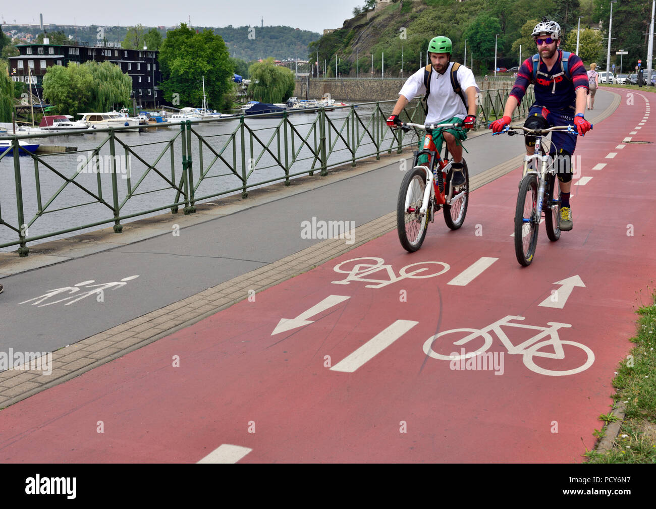 Zwei Radfahrer auf Radweg, Prag, Tschechische Republik mit Fluss Vitava Stockfoto