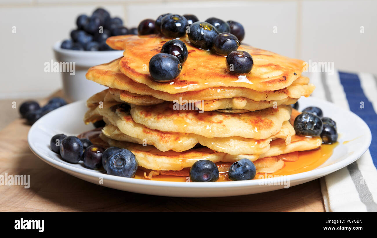 Ein Stapel von Amerikanischen Stil Blueberry Pancakes mit Heidelbeeren und beträufelt mit Sirup Stockfoto