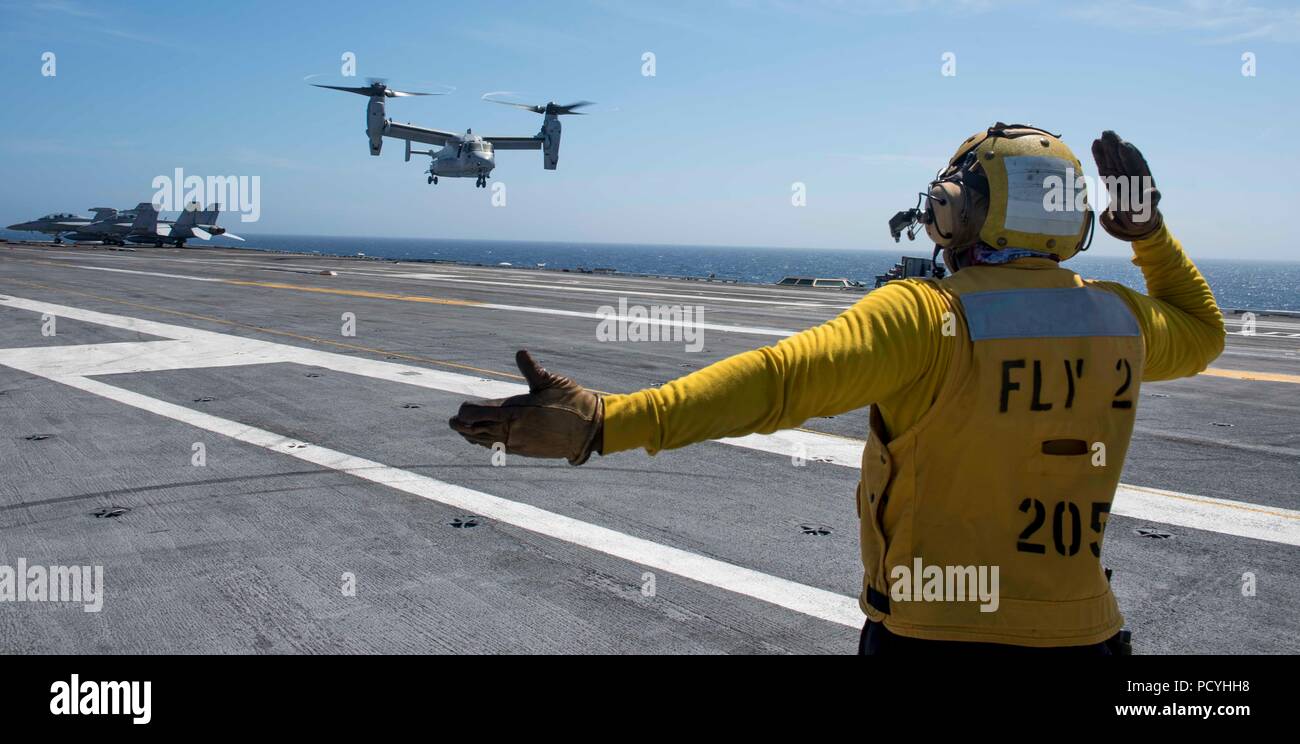 180801-N-FA 806-0194 ATLANTIK (Aug. 1, 2018) der Luftfahrt Bootsmann Mate (Handling) 1. Klasse Marlon Daley, aus New York, leitet eine MV-22 Osprey, für die Prüfung und Bewertung von Squadron (HX) 21, auf dem Flugdeck der Flugzeugträger USS George H.W. zu Land zugewiesen Bush (CVN 77). Das Schiff ist im Gange, die Durchführung von routinemäßigen Übungen Träger bereit zu halten. (U.S. Marine Foto von Mass Communication Specialist 3. Klasse Roland John) Stockfoto