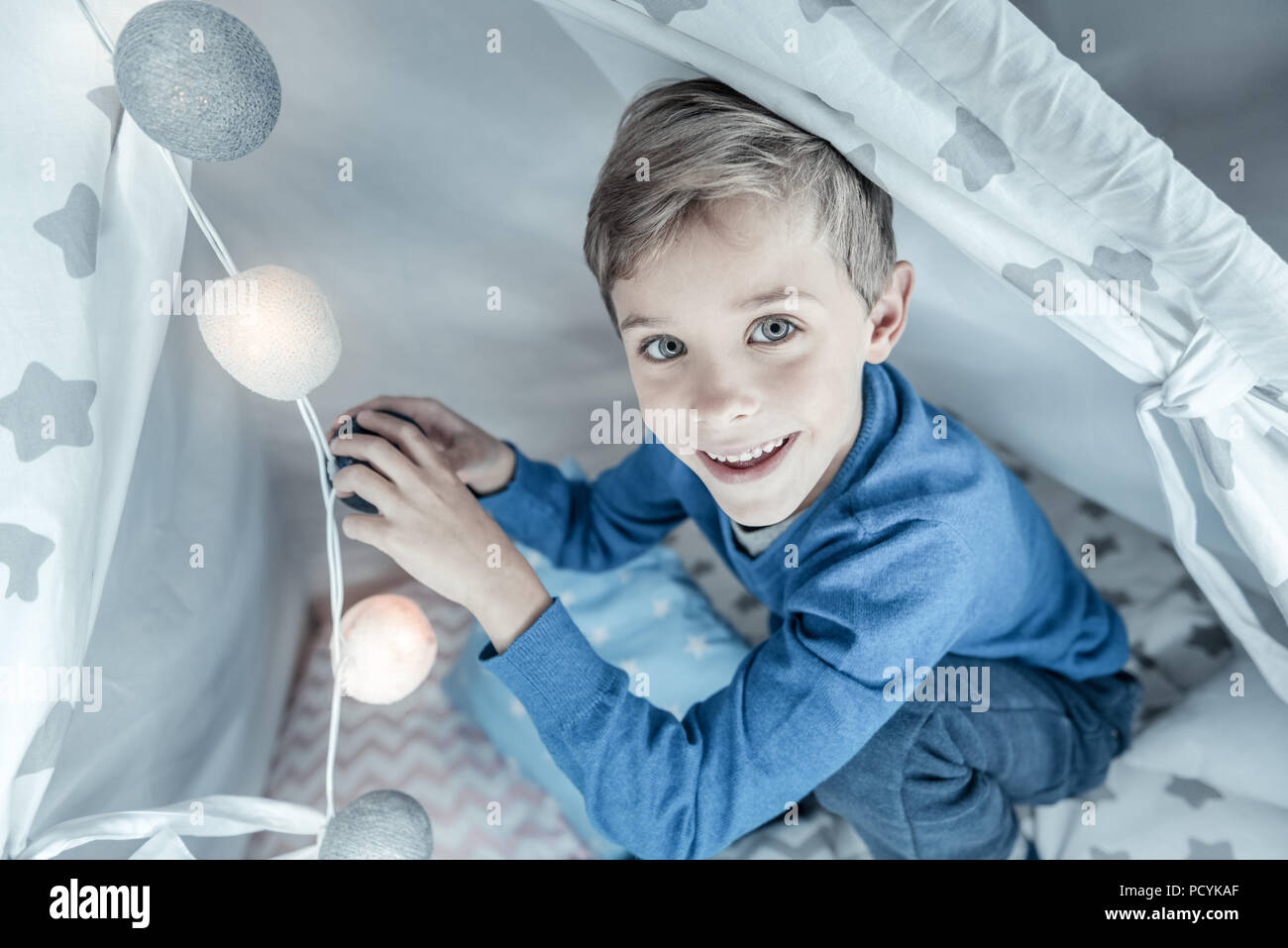 Positiv begeistert Junge spielt mit Lampe Stockfoto