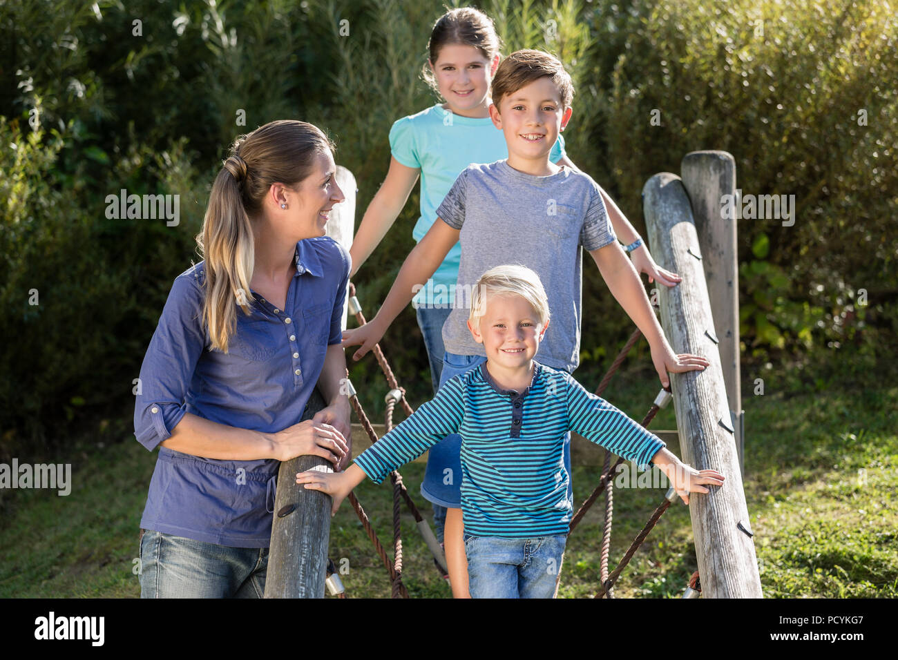Familie mit Kindern spielen auf Abenteuer Spielplatz Stockfoto