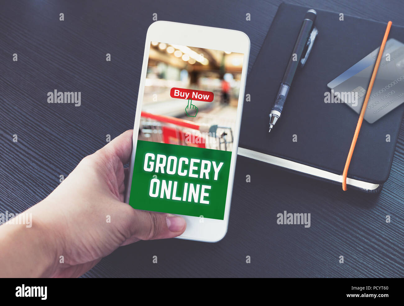 Hand Handy und bestellen Lebensmittel online zu app mit Promo Code mit Kreditkarte auf Notebook auf schwarzem Holz Tisch Hintergrund, Digitale marketi Stockfoto