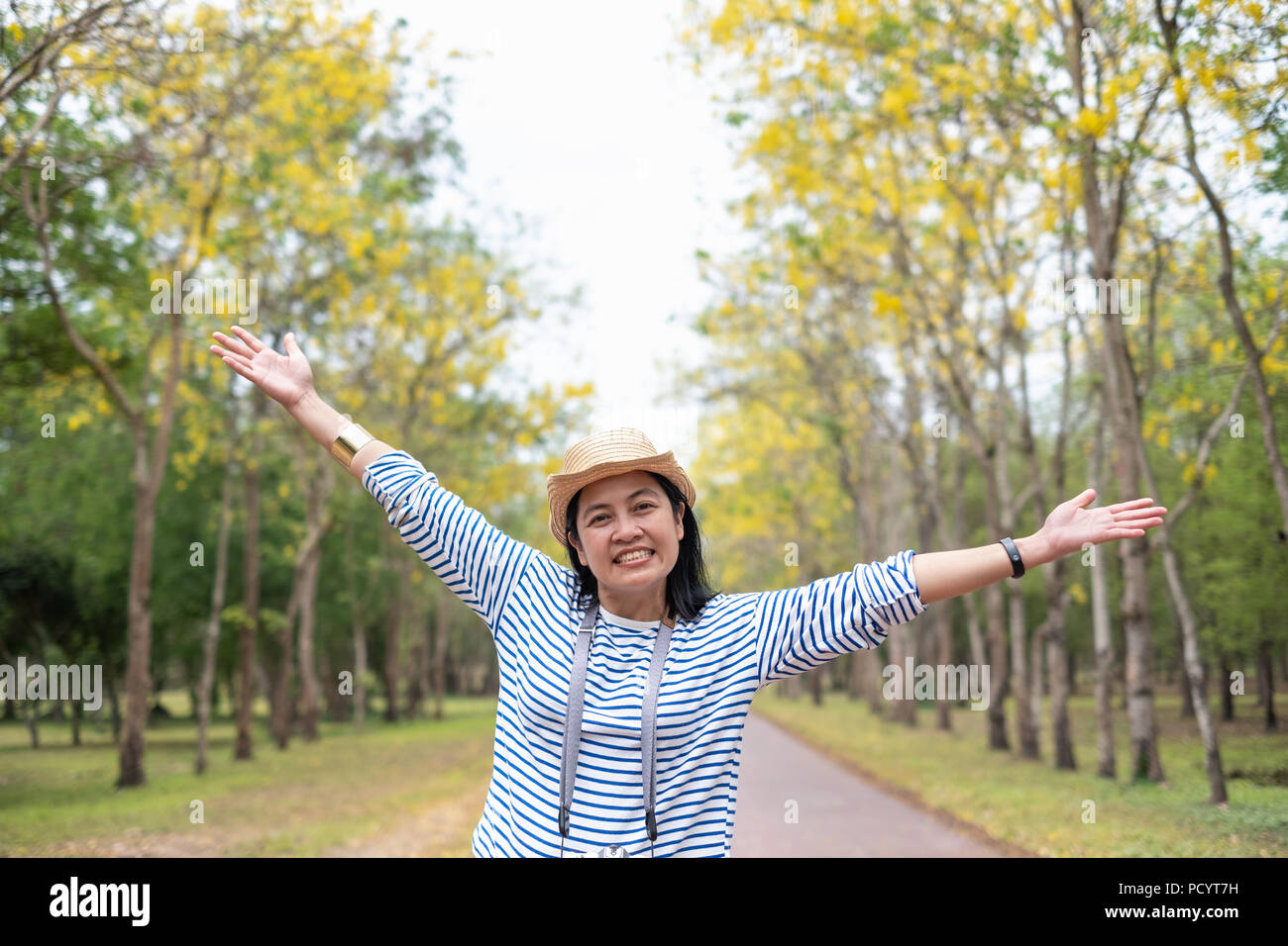 Asiatische reisende Frau backpacker Arm heben, Blick in die Kamera lächeln und mit Genießen Moment im Wald im Herbst, Freiheit Wanderlust Travel. solo Bac Stockfoto