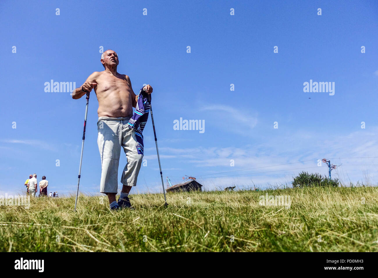 Älterer Mann mit Nordic Walking Stöcken auf der Bergwiese, Veľká Javorina, Slowakei Stockfoto