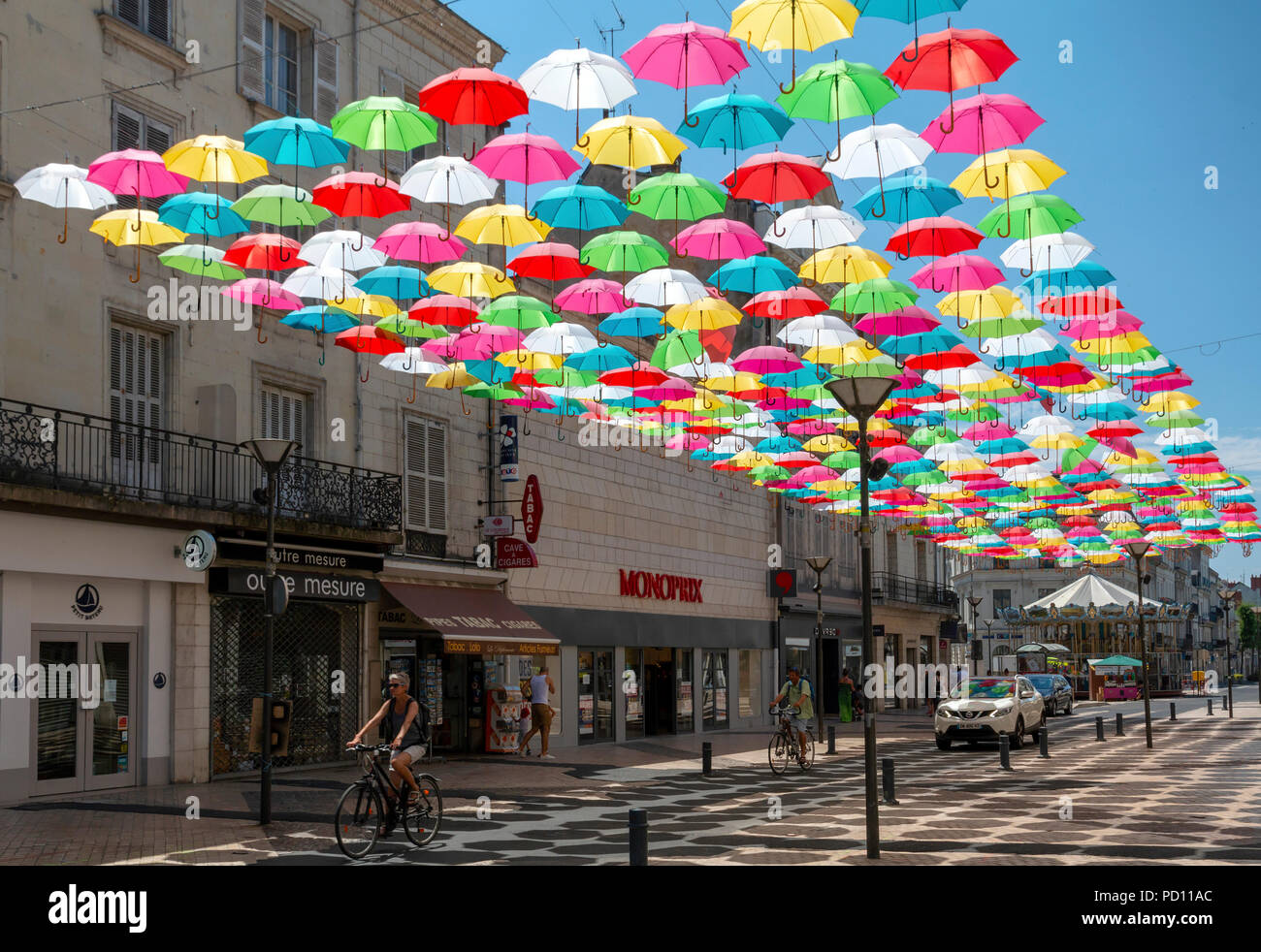 Angers, Maine-et-Loire, Frankreich - Juli 1, 2018: Schirme hängen und Schattierung Menschen auf der Rue Franklin Roosevelt in Saumur an einem warmen Sommertag Stockfoto