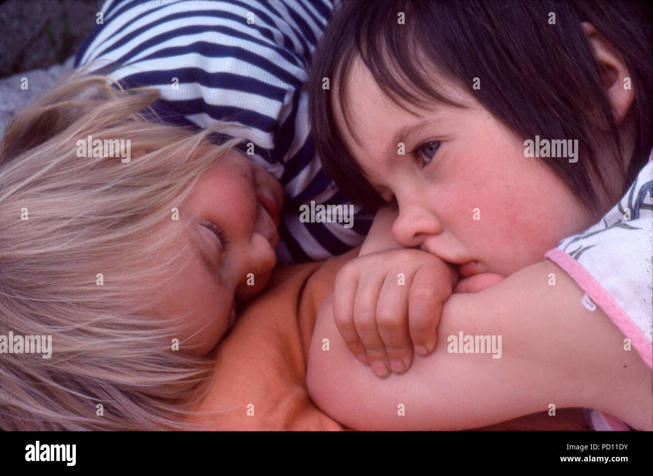 Blick über 5 Jahre altes Mädchen Kind Kinder Freunde tagträumen oder gelangweilt Schmollen nebeneinander liegend zum Kleinkind im Sommer Urlaub in den 70er 70er Jahre Großbritannien BRITISCHES KATHY DEWITT Stockfoto