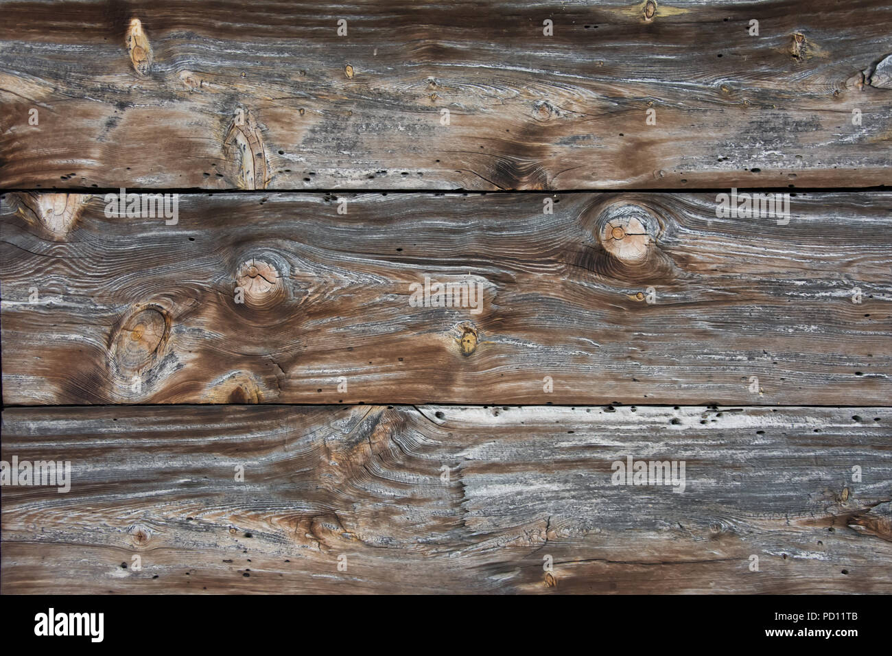 Nahaufnahme der verwitterte Wand von Platten aus Holz mit vielen Knoten und holzwurm Löcher gemacht Stockfoto