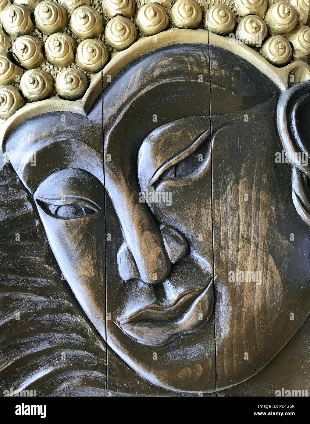 Buddha Gesicht, Holzschnitzerei. Handgefertigte Flachrelief aus Holz Stockfoto