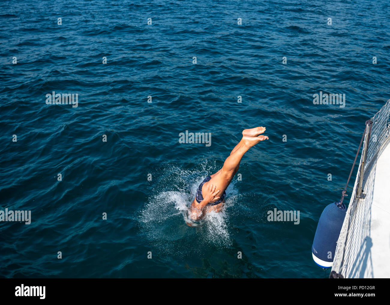 Triest, Italien, 4. August 2018. Ein Mann taucht in das Wasser von einem Segelboot in der Adria, in der Nähe von Triest. Foto von Enrique Ufer Stockfoto