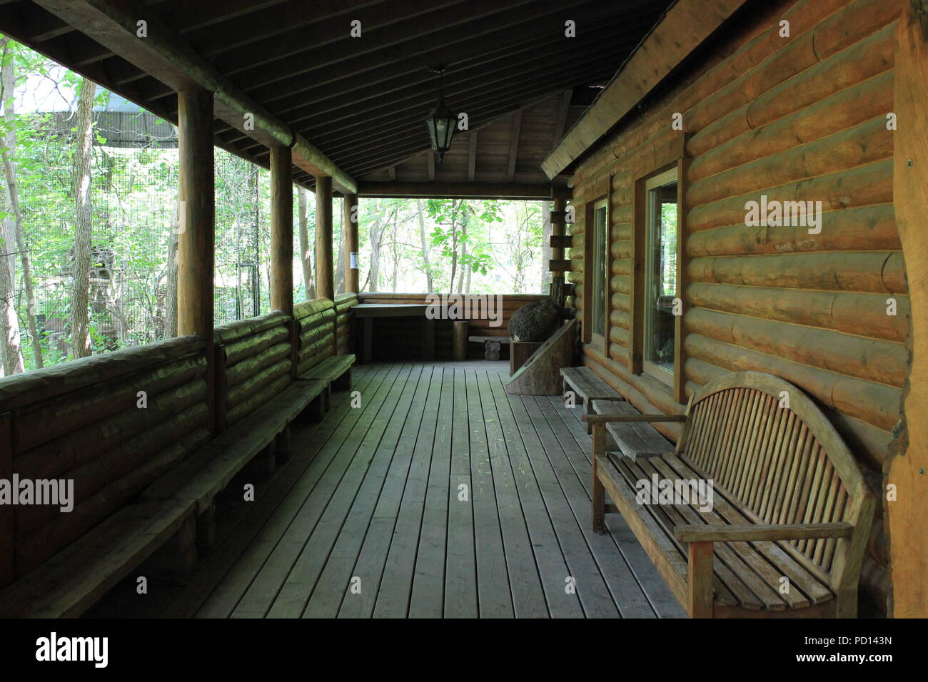 Riesige Veranda auf einer Blockhütte in der Mitte der Wiese. Stockfoto