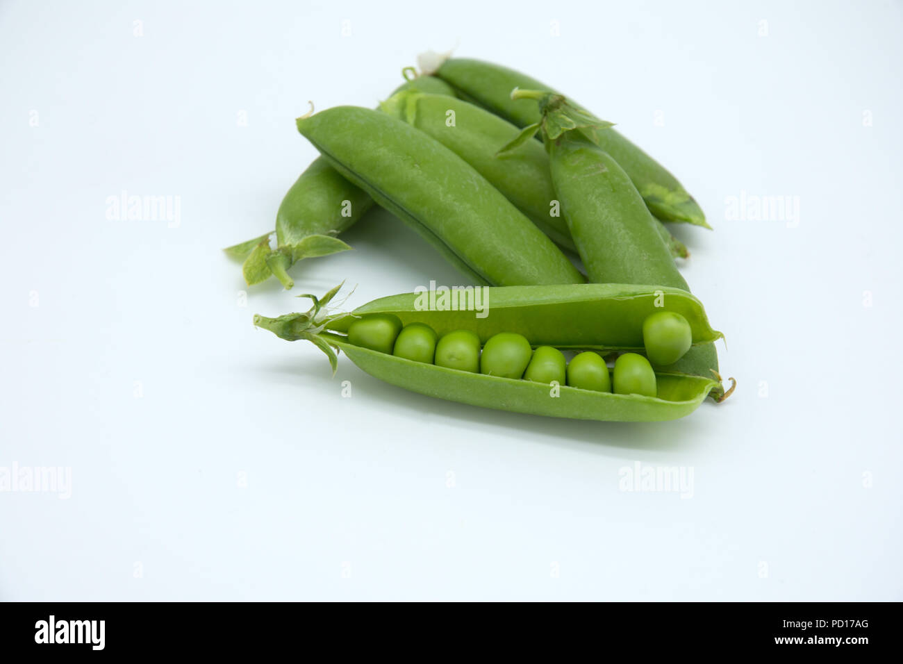 Mehrere Pea Pods mit Erbsen auf weißem Hintergrund Stockfoto
