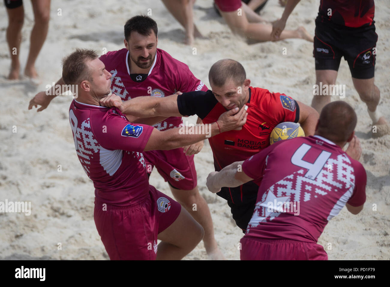 Moskau, Russland. 5 Aug, 2018. Ein moldawisches Player (Rot) und der lettischen Spieler während eines Europäischen Beach Rugby Championship Match zwischen nationalen der Männer Teams von Moldau und Lettland. Credit: Nikolay Winokurow/Alamy leben Nachrichten Stockfoto