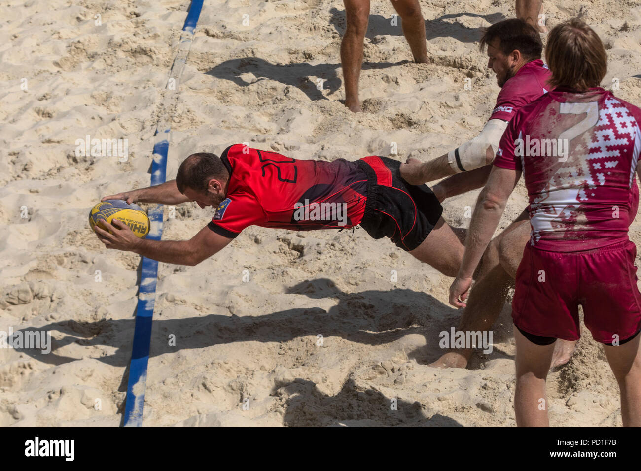 Moskau, Russland. 5 Aug, 2018. Ein moldawisches Player (Rot) und der lettischen Spieler während eines Europäischen Beach Rugby Championship Match zwischen nationalen der Männer Teams von Moldau und Lettland. Credit: Nikolay Winokurow/Alamy leben Nachrichten Stockfoto