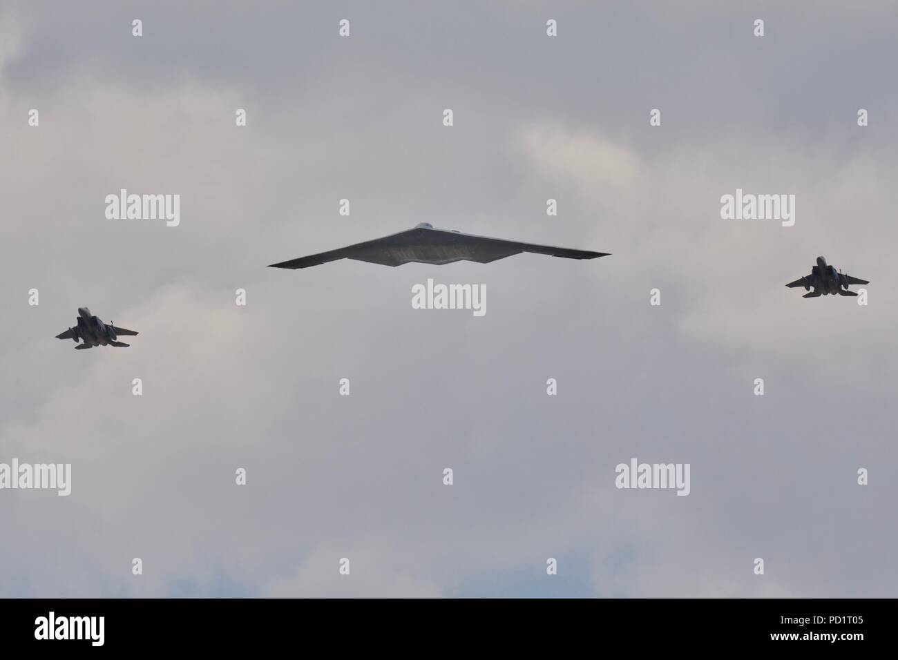 Northrop Grumman B-2 Spirit Stealth Bomber durch 2 McDonnell Douglas F-15 Kampfjets ein Flypast der RIAT 2018 begleitet Stockfoto