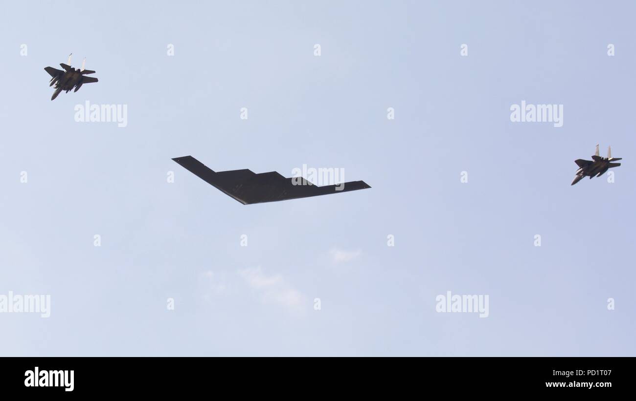 Northrop Grumman B-2 Spirit Stealth Bomber durch 2 McDonnell Douglas F-15 Kampfjets ein Flypast der RIAT 2018 begleitet Stockfoto