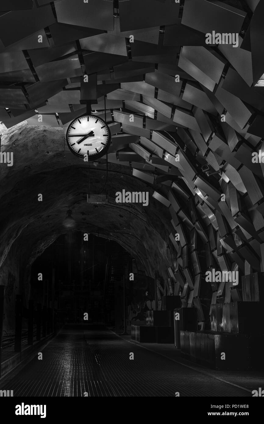 Station clock in einem Tunnel mit Wandverkleidung Stockfoto