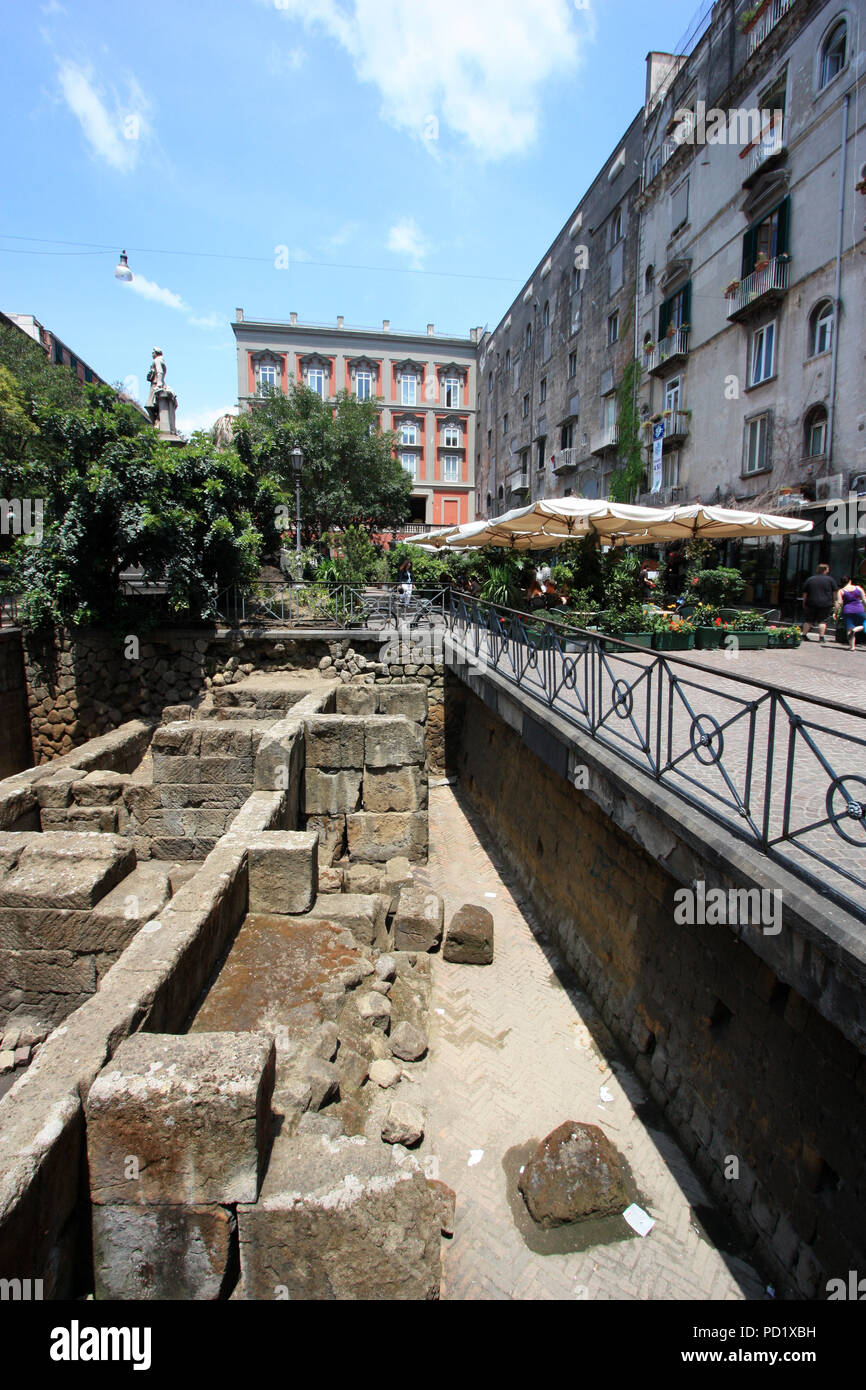 Die Menschen genießen das Leben unter Sonnenschirmen in einem Café an der Piazza Bellini in Catania, Italien, direkt neben Einige Ausgrabungen aus dem alten Römischen Reich Stockfoto