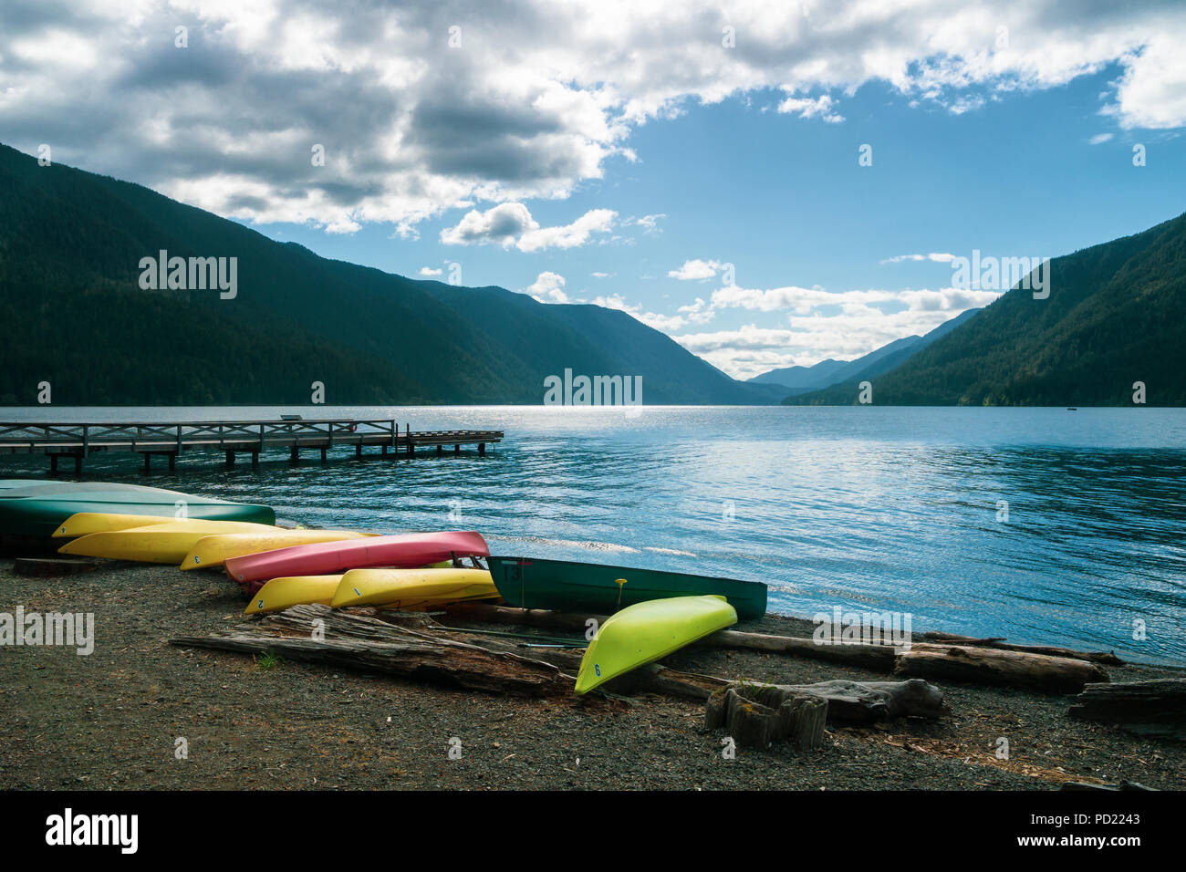 Lake Crescent, bei der die Zeile der Kajaks am Strand liegen und die Anlegestelle an einem bewölkten Tag, Olympic National Park, Washington State, USA. Stockfoto