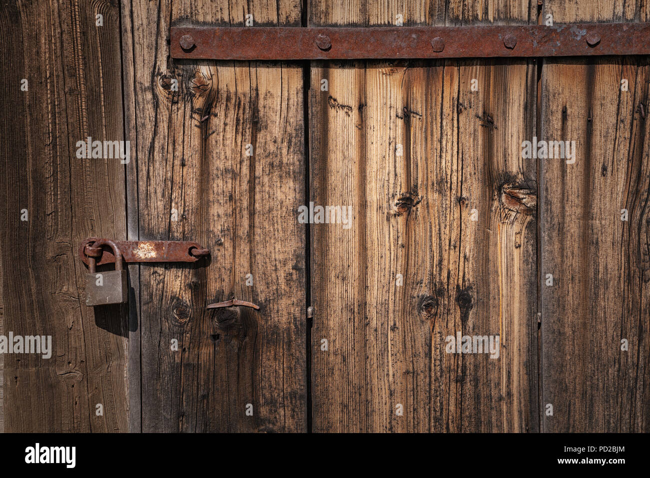 Alte Tür verlassen mit rostigen Vorhängeschloss gesichert Stockfoto